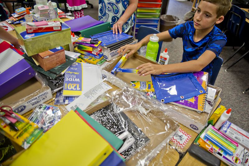 Kyle Rex organizes his supplies during the first day of classes at Davis Elementary School in Marietta on Aug. 4, 2014. Cobb schools are starting five days later this year.