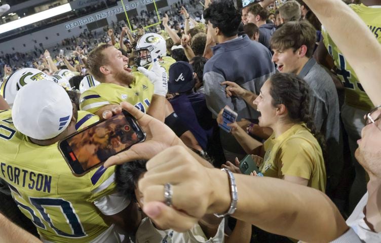 Georgia Tech players celebrate their win over North Carolina as fans storm the field.  Georgia Tech won, 46-42.  (Bob Andres for the Atlanta Journal Constitution)
