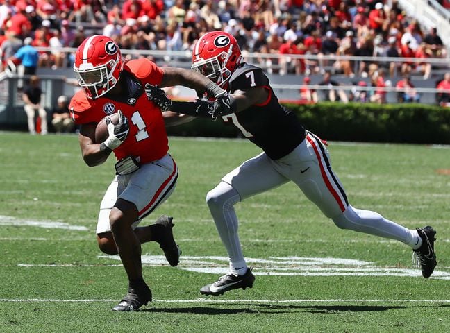 Georgia running back Trevor Etienne catches a pass and picks up yardage past defensive back Daniel Harris during the G-Day game on Saturday, April 13, 2024.  Curtis Compton for the Atlanta Journal Constitution