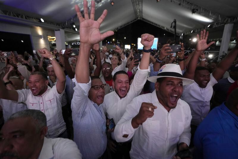 Supporters of incumbent presidential candidate Luis Abinader react after hearing the results of the first vote count during general elections in Santo Domingo, Dominican Republic, Sunday, May 19, 2024. (AP Photo/Matias Delacroix)