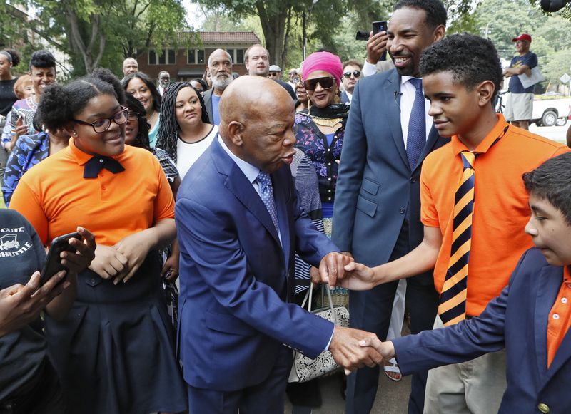 U.S. Rep. John Lewis greets seventh graders Arin Hilson, Brandon Daniels and Juan Pacheco from the John Lewis Invictus Academy as he arrived for the dedication ceremony.
