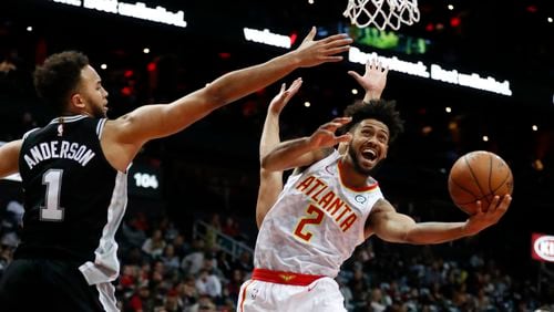 Hawks guard Tyler Dorsey (2) goes up for as shot as San Antonio Spurs forward Kyle Anderson (1) defends on Monday, Jan. 15, 2018. (AP Photo/John Bazemore)