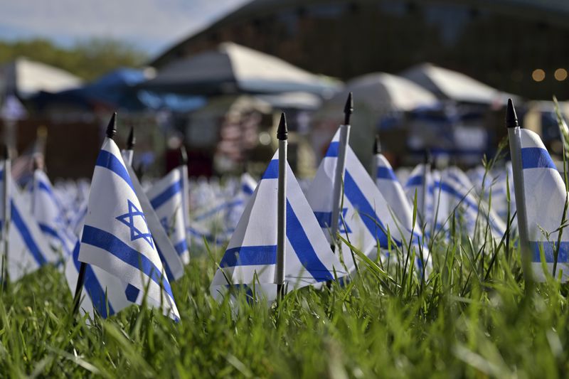A field of Israeli flags stand on the lawn beside a Pro-Palestinian encampment at MIT, Thursday, May 9, 2024, in Cambridge, Mass. MIT has suspended 23 students for participating in the encampment, and police detained at least three during a demonstration at the nearby Stata center, where demonstrators blocked traffic over claims the university was conducting research which would be used for Israeli military drones. (AP Photo/Josh Reynolds)