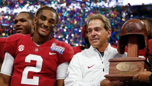 Alabama quarterback Jalen Hurts and  coach Nick Saban  with the Leather Helmet trophy after beating Florida State in last season’s Chick-fil-A Kickoff game..