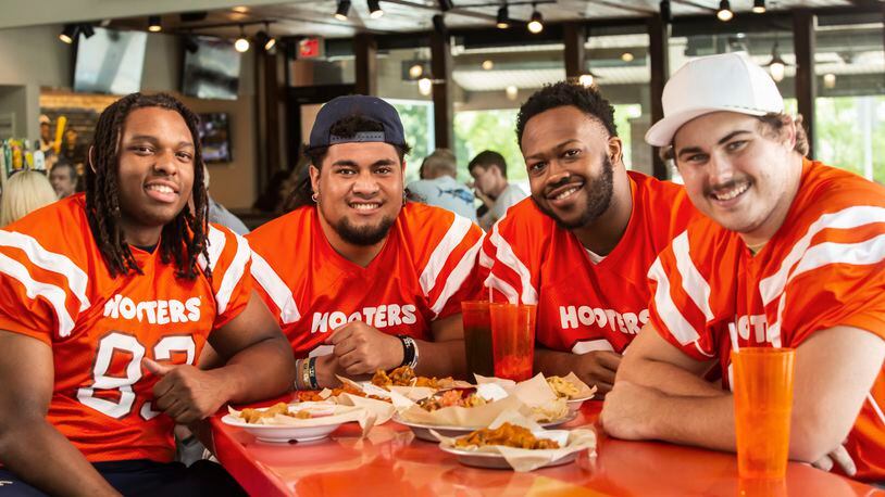 Georgia Tech offensive linemen (from left) Jordan Williams, Paula Vaipulu, Paul Tchio and Pierce Quick pose for a publicity photo for Hooters, which all four (plus three teammates) will represent in an NIL deal announced Monday. (Photo provided by Hooters of America)