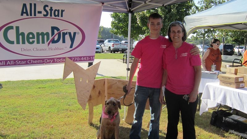 Shelly Browne (right) and her son Parker (left) along with their Airedale terrier Jack (dog) at a breast cancer event in Kennesaw. Browne owns All-Star Chem-Dry, which offers free carpet cleanings to breast cancer patients.