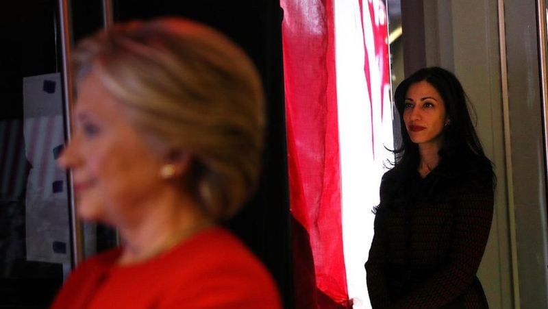 Huma Abedin (R) looks on as Democratic presidential nominee former Secretary of State Hillary Clinton stands backstage before a campaign rally at North Carolina State University on November 8, 2016 in Raleigh North Carolina. 