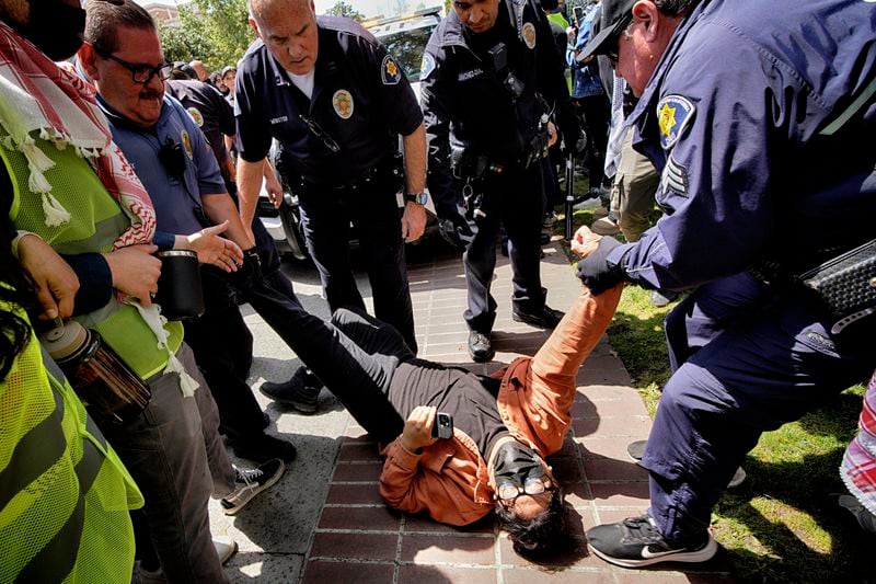 FILE - A University of Southern California protester is detained by USC Department of Public Safety officers during a pro-Palestinian occupation at the campus' Alumni Park, Wednesday, April 24, 2024, in Los Angeles. (AP Photo/Richard Vogel, File)