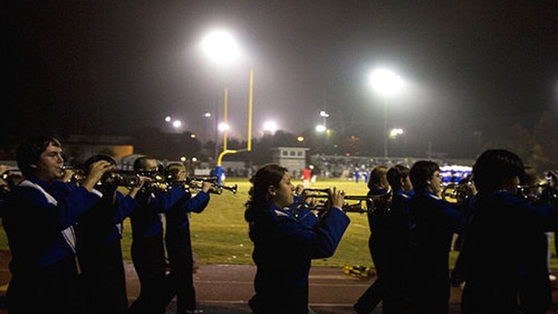 The Walton High School marching band enters Raider Valley before the start of the game.