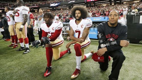 San Francisco 49ers quarterback Colin Kaepernick (7) and outside linebacker Eli Harold (58) kneel during the playing of the national anthem before an NFL football game on Dec. 18, 2016, against the Atlanta Falcons in Atlanta. The quarterback would later find himself blackballed from playing in the NFL. JOHN BAZEMORE / ASSOCIATED PRESS