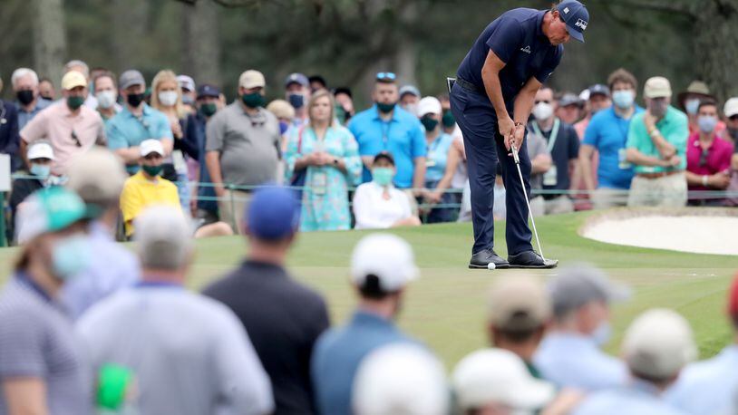 April 10, 2021, Augusta: Patrons watch as Phil Mickelson putts on the seventh green during the third round of the Masters at Augusta National Golf Club on Saturday, April 10, 2021, in Augusta. Curtis Compton/ccompton@ajc.com