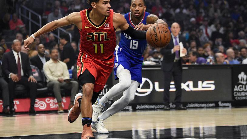 Atlanta Hawks guard Trae Young, left, receives an inbound pass while Los Angeles Clippers guard Rodney McGruder defends during the first half of an NBA basketball game in Los Angeles, Saturday, Nov. 16, 2019. (AP Photo/Kelvin Kuo)