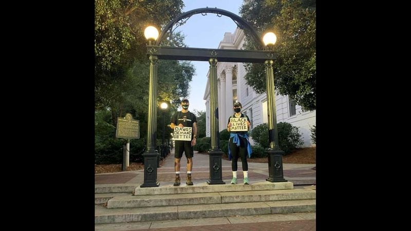 Two supporters of Dawgs Demand Better stand in front of the famed arch on the University of Georgia's main campus in Athens in a photo it posted on Instagram. The group was created in June 2020 to push for changes in how UGA treats Black students and to address its history with the Black community. (Courtesy of Dawgs Demand Better)