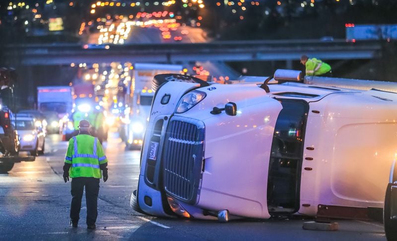 A tractor-trailer hauling 41,000 pounds of cheese overturned on Ga. 20 in Gwinnett County early Monday. The driver is accused of driving too fast for conditions. JOHN SPINK / JSPINK@AJC.COM