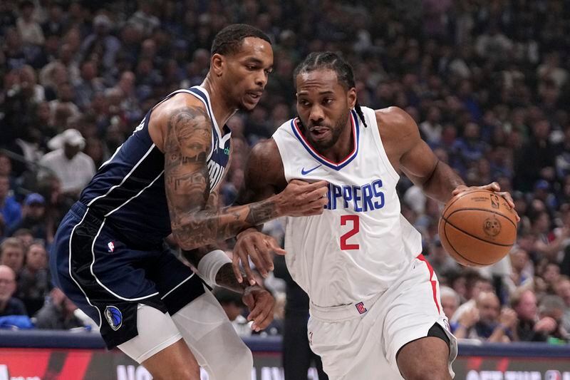 Dallas Mavericks forward P.J. Washington, left, defends as Los Angeles Clippers' Kawhi Leonard (2) works to the basket during the first half of Game 2 of an NBA basketball first-round playoff series Friday, April 26, 2024, in Dallas. (AP Photo/Tony Gutierrez)