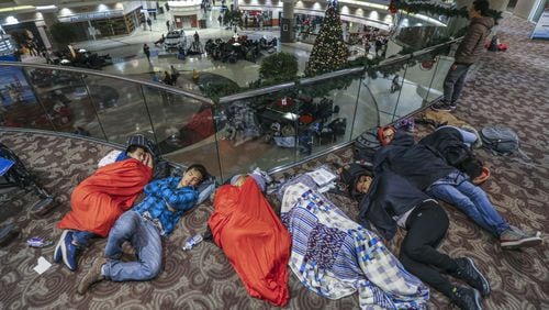 Many stranded travelers slept in the atrium at Hartsfield-Jackson International Airport Sunday night, after a massive power outage forced airlines to cancel more than 1,100 flights and created a logistical nightmare during the already-busy holiday travel season. JOHN SPINK/JSPINK@AJC.COM