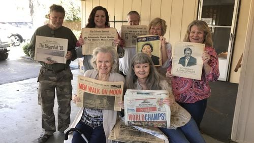 Holding some of her newspapers are five of Mrs. Roberta Lee Whitley's children: (from left to right) Wayne Whitley, Annette Duckworth, Gary Whitley, Gail Campbell and Joyce Rolin. Missing is daughter Caroline Hunt. In the front row are Roberta Whitley and the AJC's Amy Chown.