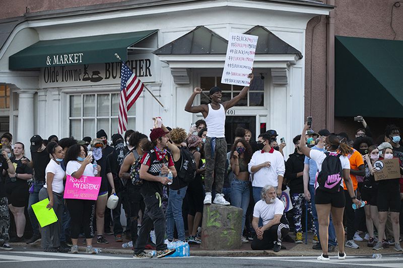 Demonstrators converge on the slave auction block in downtown Fredericksburg, Va., Tuesday, June 2, 2020, as a curfew begins. Police dispersed the crowd without using force.