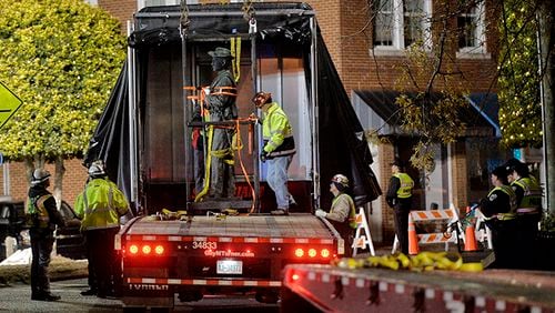 Workers load a Confederate statue onto a truck after it was removed from its spot in front of the historic Chatham County Courthouse early Wednesday in Pittsboro, N.C.