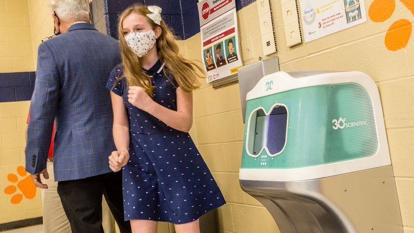 Lexi Walton, 11, finishes up her first use of "Iggy," 3Oe Scientific's aqueous ozone hand-rinsing station that was installed in the Bryant Elementary School cafeteria in Mableton. The Iggy hand-rinsing stations installed in Cobb schools have stopped working or malfunctioned more than 100 times since their rollout began in 2020, district records show. (Jenni Girtman for The Atlanta Journal-Constitution)