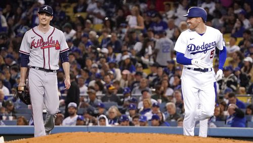 Los Angeles Dodgers' Freddie Freeman, right, smiles at Atlanta Braves starting pitcher Max Fried after being thrown out at first during the fourth inning of a baseball game Tuesday, April 19, 2022, in Los Angeles. (AP Photo/Mark J. Terrill)