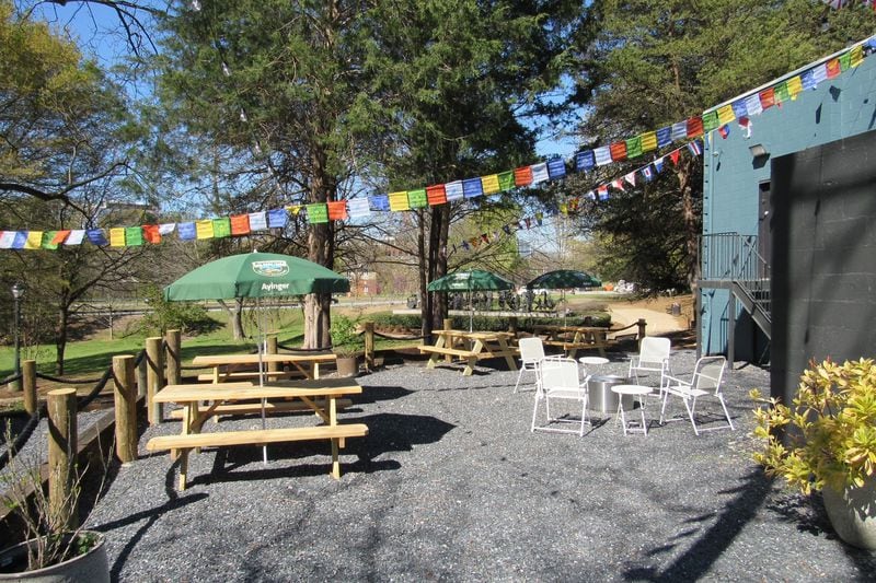 The rear patio, also known as the Backyard, at the Best Sandwich Shop and Wurst Beer Hall. The Wurst space has an oak bartop made with reclaimed wood from Piedmont Park, flags and banners from sports teams, televisions showing U.S. and European sports. / Courtesy of the Best Sandwich Shop