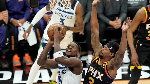 Minnesota Timberwolves guard Anthony Edwards (5) tries to get off a shot as Phoenix Suns guard Bradley Beal (3) defends during the first half of Game 4 of an NBA basketball first-round playoff series, Sunday, April 28, 2024, in Phoenix. (AP Photo/Ross D. Franklin)