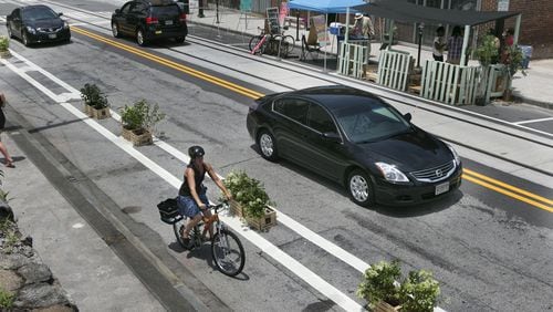 A woman rides her bike on the the safe bikes lanes created by plants in Atlanta on June 22, 2014.