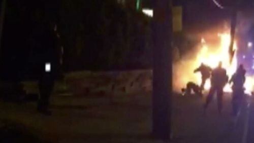 In this still image from video shot on June 4, 2017, a bystander is kicked by Jersey City, N.J., police officers as he lies on the ground following a police chase that ended in a fiery crash. The bystander, 28-year-old Miguel Feliz, was seriously burned after his car, which was struck by a man fleeing police, burst into flames.