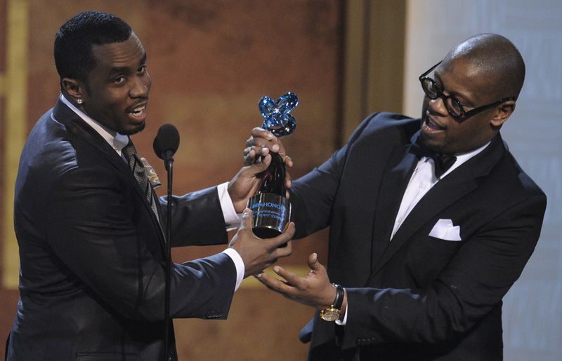 FILE - In this Jan. 16, 2010 file photo, media executive Andre Harrell, right, presents an award to Sean "Diddy" Combs at the Warner Theatre during the 2010 BET Hip Hop Honors in Washington. Harrell, the Uptown Records founder who shaped the sound of hip-hop and R&B in the late 80s and 90s with acts like Mary J. Blige and Heavy D and also launched the career of mogul Sean “Diddy” Combs, has died, several members of the music community revealed late Friday, May 8, 2020. He was 59. (AP Photo/Nick Wass)