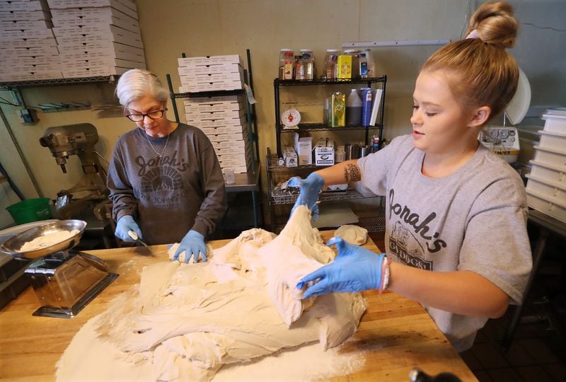 April 22, 2020 Forsyth: Laurie Thomas (left), owner of Jonah's on Johnston, and Makenna Purvis make up a batch of pizza dough on Wednesday, April 22, 2020, in Forsyth. The Monroe County Commission recently voted to urge Gov. Brian Kemp and President Donald Trump to begin reopening the economy by the end of the month, becoming one of the first local Georgia governments to formally demand a speedier end to coronavirus restrictions.   Curtis Compton ccompton@ajc.com
