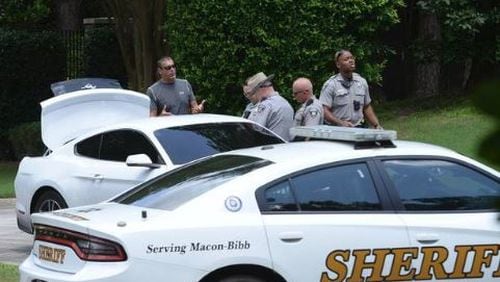 Former major league pitcher Kevin Brown (left) speaks with Bibb County deputies after reportedly capturing two mail-theft suspects.