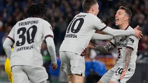 Leverkusen's Florian Wirtz, center, celebrates after scoring his side's opening goal with his teammates during the Europa League semifinal first leg soccer match between Roma and Bayer Leverkusen at Rome's Olympic Stadium in Rome, Italy, Thursday, May 2, 2024. (AP Photo/Andrew Medichini)