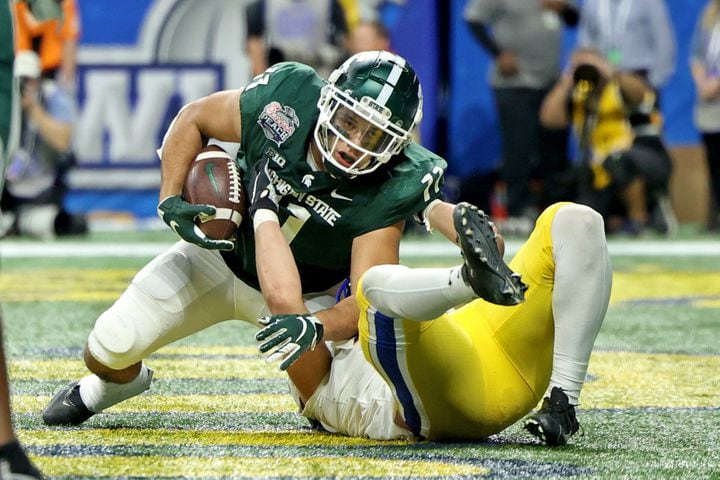 Michigan State Spartans tight end Connor Heyward (11) secures a touchdown reception against Pittsburgh Panthers linebacker Brandon George (30) in the fourth quarter of the Chick-fil-A Peach Bowl at Mercedes-Benz Stadium in Atlanta, Thursday, December 30, 2021. Heyward is a graduate of Peachtree Ridge high school. JASON GETZ FOR THE ATLANTA JOURNAL-CONSTITUTION