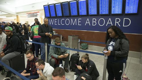 Delta passengers wait in line at Hartsfield-Jackson International Airport after Delta Air Lines grounded all domestic flights due to automation issues, Sunday, Jan. 29, 2017, in Atlanta. (AP Photo/Branden Camp)