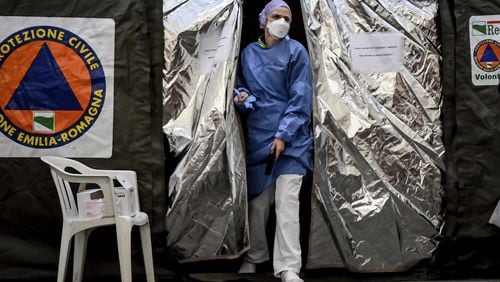 A paramedic at a tent set up by the Italian Civil Protection agency outside the emergency ward of a hospital in Northern Italy on Feb. 27, 2020. Italy has taken strong measures to try and contain the coronavirus’ spread. (Claudio Furlan/Lapresse via AP)
