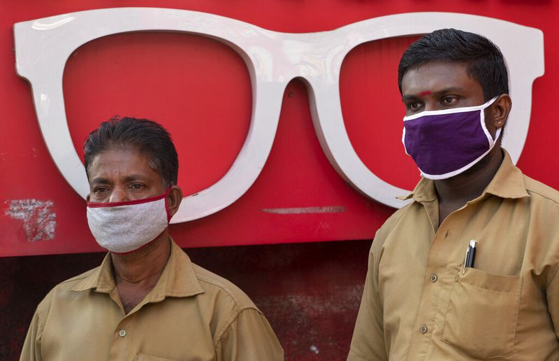 Auto rickshaw drivers wearing masks as a precaution against COVID-19 await customers near an optical shop in Kochi, Kerala state, India, Wednesday, June 24, 2020. India is the fourth hardest-hit country by the coronavirus in the world after the U.S., Russia and Brazil. (AP Photo/R S Iyer)