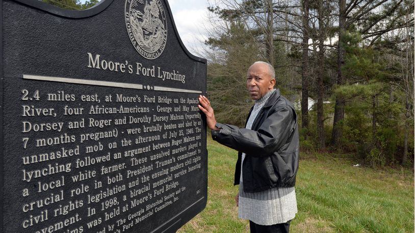Walton County civil rights activist Robert Howard stands next to Moore’s Ford Lynching historical marker on US 78 Six Miles East of Monroe, at Locklin Road at Oconee County line on Tuesday, March 25, 2014. Now, nearly 68 years after two African-American couples were lynched on Moore’s Ford Bridge in Walton County, Ga., local civil rights leaders who continue to investigate say they have unearthed credible information that could finally solve the case. The source is a 55-year-old white Monroe native who claims his late uncle and at least another dozen locals, all members of the Ku Klux Klan, participated in the July 25, 1946, killings of Roger and Dorothy Malcom and George and Mae Murray Dorsey. HYOSUB SHIN / HSHIN@AJC.COM
