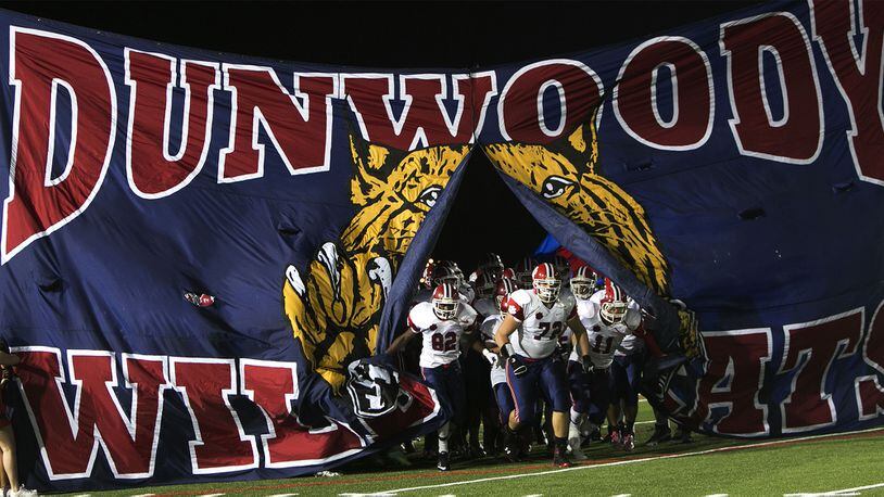 The Dunwoody Wildcats varsity football team take the field before their game against the Carver Panthers Friday, Sept. 11, 2015, at Lakewood Stadium in Atlanta. (Phil Skinner/For the AJC)