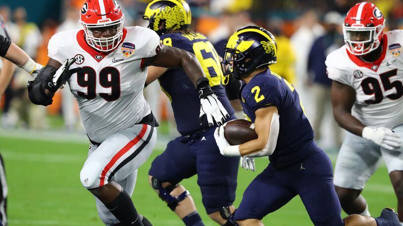 The combination of immense size and surprising quickness -- here on display while running down Michigan back Blake Corum for a loss in the national semifinal -- makes Georgia's Jordan Davis a projected first-rounder in the NFL draft. Curtis Compton / Curtis.Compton@ajc.com