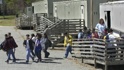 Students exit temporary portable classrooms at DeKalb County’s Cary Reynolds Elementary School. DeKalb County School District and Dunwoody city officials are not saying how scores of portable classrooms at schools in the city did not receive certificates of occupancy. (AJC FILE PHOTO)