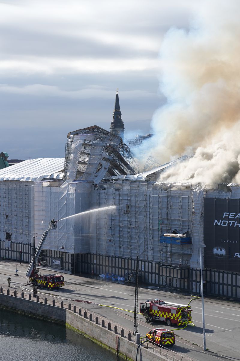 Smoke rise out of the Old Stock Exchange, Boersen, in Copenhagen, Denmark, Tuesday, April 16, 2024. One of Copenhagen’s oldest buildings is on fire and its iconic spire has collapsed. The roof of the 17th-century old Stock Exchange, or Boersen, that was once Denmark’s financial center, was engulfed in flames Tuesday. (Emil Helms/Ritzau Scanpix via AP)