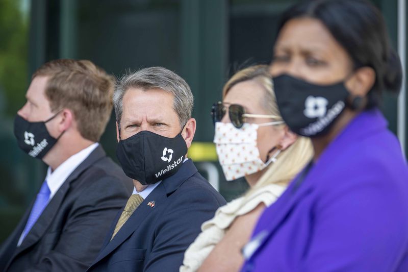 Gov. Brian Kemp wears a mask Thursday as he waits to speak during a ribbon-cutting ceremony for the new Wellstar Kennestone Hospital Emergency Department building in Marietta. The governor encourages Georgians to wear masks as a way to combat the spread of the coronavirus, but he says making it a requirement would be "a bridge too far." (ALYSSA POINTER / ALYSSA.POINTER@AJC.COM)