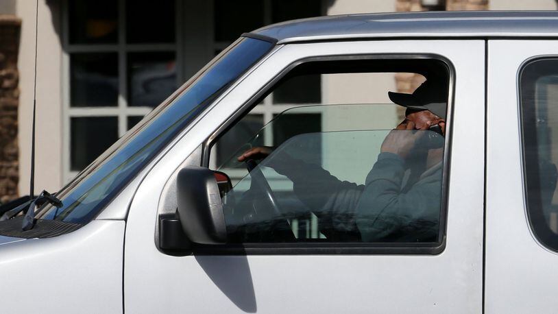 A man talks on his cellphone while driving down Northside Parkway in Atlanta. (BOB ANDRES / bandres@ajc.com / January 2015 AJC file photo)