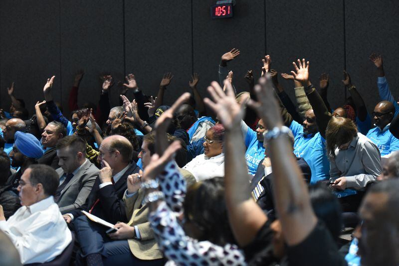 March 30, 2016 Atlanta - Ridesharing supporters express their supports by raising their hands during the Transportation Committee hearing on the airport’s draft proposal for ridesharing operations on Wednesday, March 30, 2016. Atlanta's city council is expected to consider a plan for Uber and other ride-booking services to operate at the airport under certain conditions. HYOSUB SHIN / HSHIN@AJC.COM