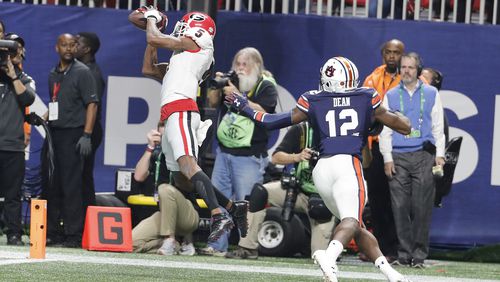 Georgia wide receiver Terry Godwin (5) makes a touchdown catch against Auburn defensive back Jamel Dean (12) during the second half of the Southeastern Conference championship NCAA college football game, Saturday, Dec. 2, 2017, in Atlanta. (AP Photo/David Goldman)