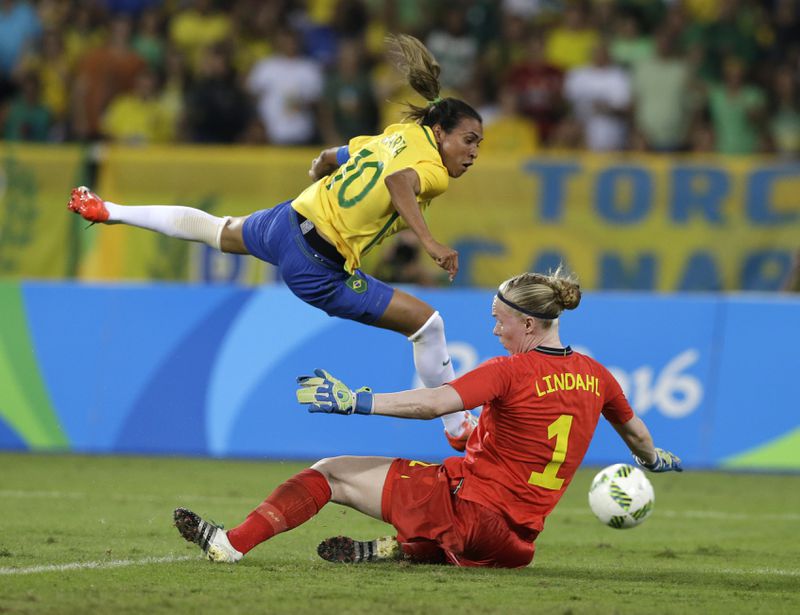 FILE - Brazil's Marta, left, leaps over Sweden's goalkeeper Hedvig Lindahl as she attempts a shot during a group E match of the women's Olympic football tournament at Rio Olympic Stadium in Rio De Janeiro, Brazil, Aug. 6, 2016. Brazil won the game 5-1. Marta, the six-time women's world player of the year, plans to retire from the national team after 2024. (AP Photo/Leo Correa)