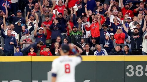 Fans in the outfield react as Atlanta Braves left fielder Eddie Rosario (8) walks out to the outfield before the start of the fifth inning after Rosario hit a three-run home run during the fourth inning. Curtis Compton / curtis.compton@ajc.com