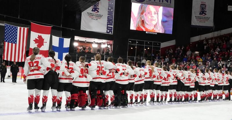 Canada players watch as they raise the flags following their gold medal win over United States at the women's world hockey championships in Utica, N.Y., Sunday, April 14, 2024. (Christinne Muschi/The Canadian Press via AP)