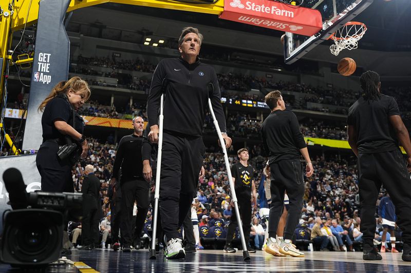 Minnesota Timberwolves head coach Chris Finch uses crutches to head to the bench in the second half of Game 1 of an NBA basketball second-round playoff series against the Denver Nuggets Saturday, May 4, 2024, in Denver. (AP Photo/David Zalubowski)